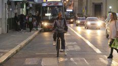 El ciclista espera que cruce la mujer mientras se vienen los autos y colectivos. El ciclista espera que cruce la mujer mientras se vienen los autos y colectivos.