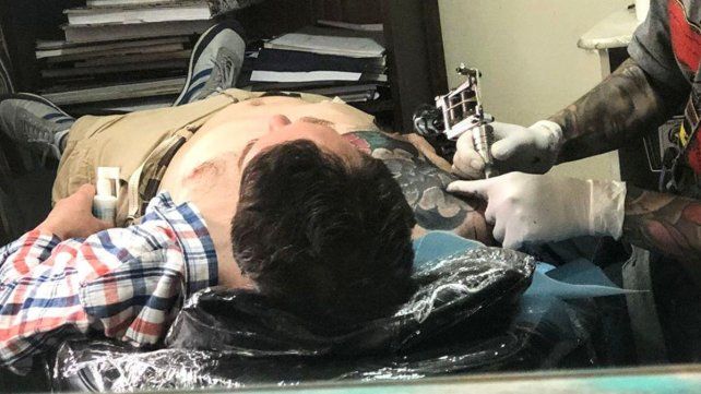 Fermín Darchez tatuando a una buena distancia del cliente.