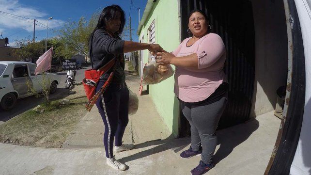 Chuni entregando el pan a una vecina.
