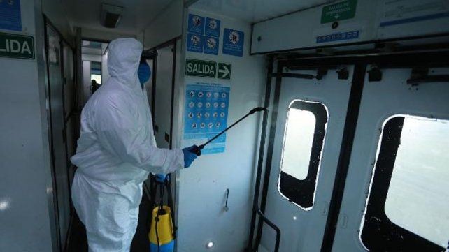 Un empleado higienizando uno de los vagones del tren que vuelve a unir Paraná con Colonia Avellaneda. 