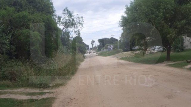 A lo lejos, las máquinas trabajando sobre calle Tibiletti de Paraná, y a pocos metros vecinos que piden A lo lejos, las máquinas trabajando sobre calle Tibiletti de Paraná, y a pocos metros vecinos que piden