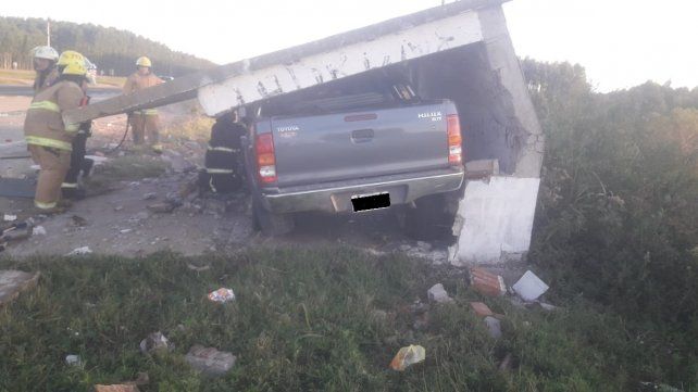 Los bomberos trabajan para retirar la camioneta del interior de la garita.