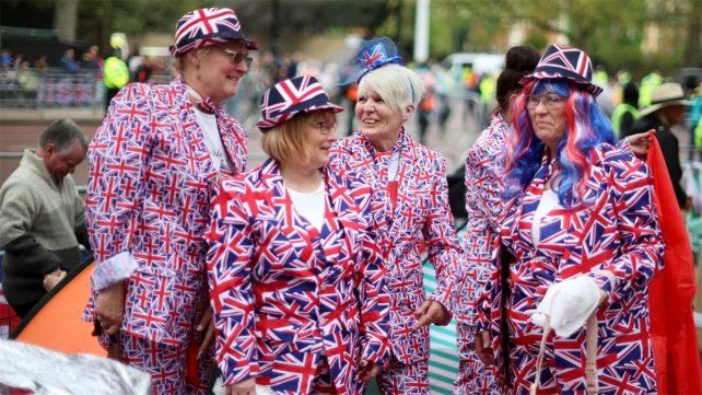Con trajes de la bandera británica un grupo de ciudadanos se reunía frente al Palacio de Buckingham antes de la coronación del rey Carlos y Camila