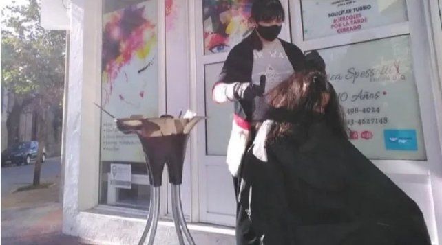 Peluquera entrerriana corta el pelo en la vereda: