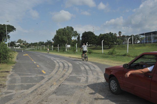 Autos y ciclistas conviven en la calle que pasa frente a la escuela de policía.