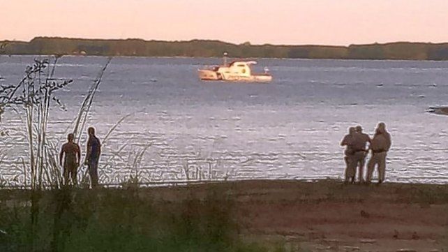 Personal de Prefectura en la playa, durante las tareas de búsqueda del joven en el lago Salto Grande. 