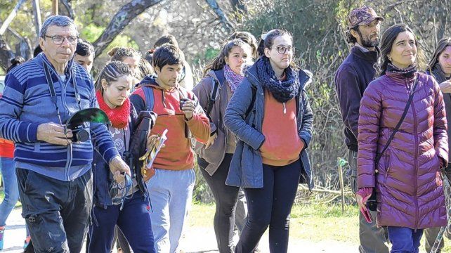 Parque. Amantes de las aves caminan en grupo para escucharlas.