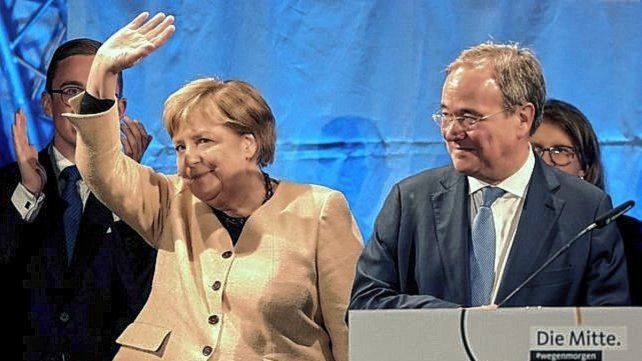 La canciller alemana saluda flanqueada por Armin Laschet, el candidato de la Unión Democrata Cristiana (CDU) para los comicios de este domingo. Bernd Wustneck / Agencia DPA vía AP